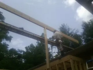 Carpenter setting a ridge beam over a new addition frame — Ice Dam Removal by Roofing Brothers in De Soto