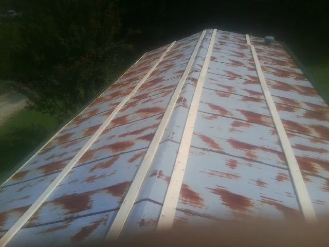 Rusted metal roof panels with new wood purlins before replacement — Storm Damage Roof Repair in De Soto by Roofing Brothers